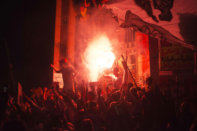 Egyptian supporters of the April 6 movement light flares while shouting slogans against the president and the Muslim brotherhood during a demonstration outside the Superior Court building in Cairo on April 6, 2013.(AFP Photo / Gianluigi Guercia)