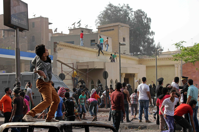 Unidentified Egyptians throw stones towards Coptic Christians during sectarian clashes outside the Egyptian Coptic cathedral in Cairo's Abbassiya neighbourhood on April 7, 2013 (AFP Photo / STR)