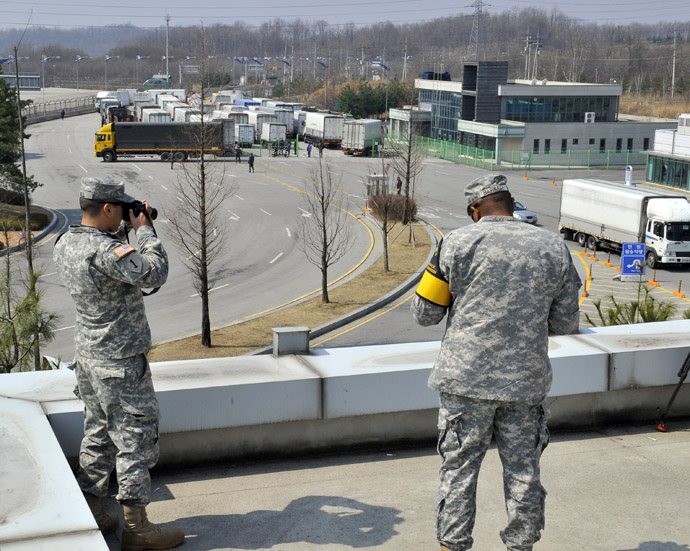 US soldiers take pictures as South Korean trucks return back after they were banned access to Kaesong joint industrial park in North Korea, at a military check point of the inter-Korean transit office in Paju on April 3, 2013. (AFP Photo/Jung Yeon-Je)
