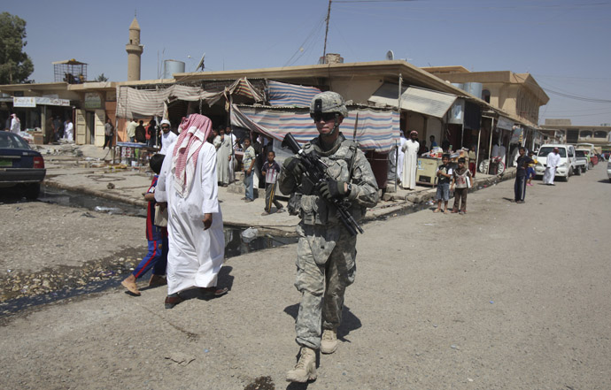 A U.S. soldier on patrol walks past Iraqi residents in Mosul, 390 km (240 miles) north of Baghdad, September 5, 2010. (Reuters/Saad Shalash)