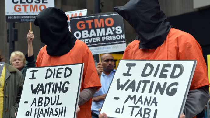 People dress in orange jumpsuits and black hoods as activists demand the closing of the US military's detention facility in Guantanamo during a protest, part of the Nationwide for Guantanamo Day of Action, April 11, 2013.(AFP Photo / Stan Honda)
