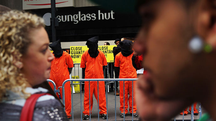 Pedestrians in Times Square watch as protesters, dressed in orange prison jumpsuits, participate in a nationwide "Day of Action to Close Guantanamo & End Indefinite Detention" on April 11, 2013.(AFP Photo / Spencer Platt)