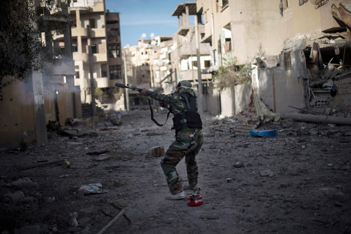 Syrian rebel from the Shuhaa Arfie brigade, uses his modified rifle to fire a home made pipe bomb towards government positions (AFP Photo / Zac Baillie)