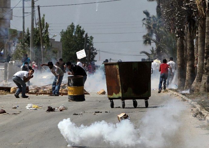 Palestinians proteface during clashes with Israeli security forces following a protest against the expropriation of Palestinian land by Israel in the West Bank village of Silwad, east of Ramallah, on April 12, 2013. (AFP Photo / Abbas Momani)