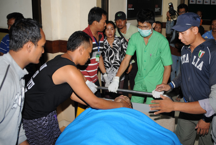An injured passenger (C) from the Lion Air plane that missed the runway at Bali's international airport is attended to at hospital as people arrive for treatment in Kedongan near Denpasar on Bali island on April 13, 2013 (AFP Photo / Sonny Tumbilaka)