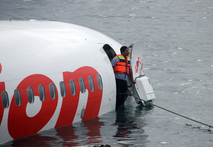 This handout photo released by the Indonesian Police on April 13, 2013 shows a man standing at the door of a Lion Air Boeing 737 after the aircraft skidded off the runaway during landing at Bali's international airport near Denpasar (AFP Photo / Indonesian Police)