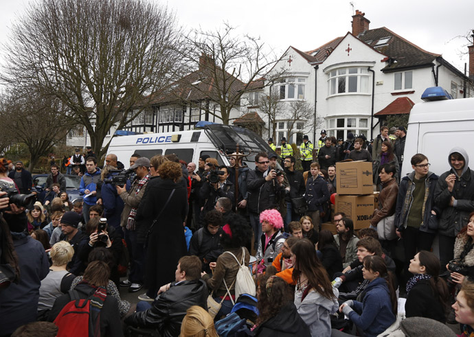 Demonstrators sit in the road during a UK Uncut protest outside the home of welfare minister David Freud, in north London April 13, 2013. (Reuters/Luke MacGregor)
