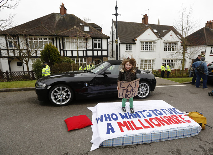 Eight Year old Lucian Shalmy-Freeman jumps on a mattress during a UK Uncut protest outside the home of welfare minister David Freud, in north London April 13, 2013. (Reuters/Luke MacGregor)