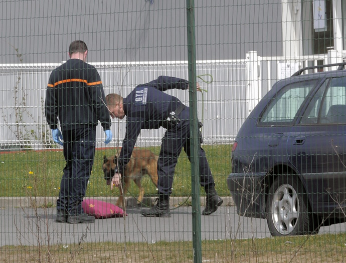 Policemen patrol with a dog to find evidences, on April 13, 2013 in a yard of Sequedin prison, after an inmate, Redoine Faid, managed to escape using explosives after holding five wardens hostages. (AFP Photo/Francois Lo Presti)