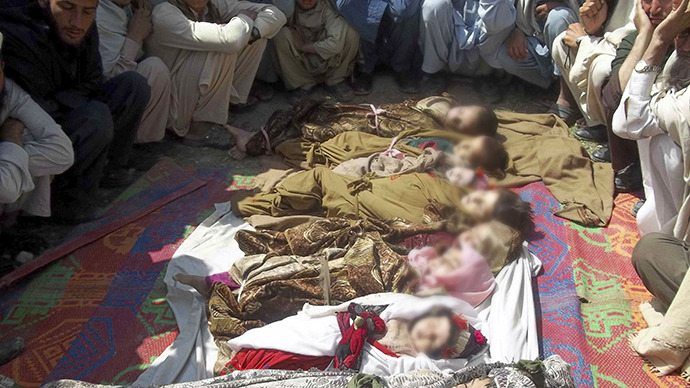 Afghan villagers sit near the bodies of children who they said were killed during an air strike in Kunar province April 7, 2013. (Reuters)