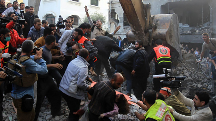 Palestinian men carry the dead bodies of children from the al-Dallu family out from the rubble after an Israeli missile struck a family home killing at least seven members of the same family in Gaza City on November 18, 2012. (AFP Photo/Mahmud Hams)