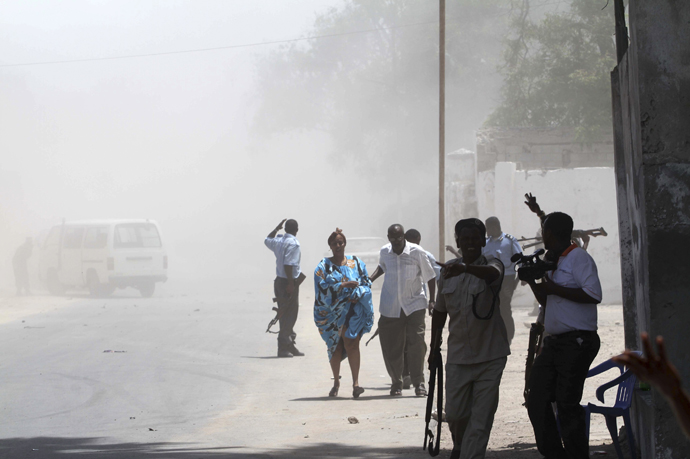 Somali policemen clear people from the scene of a deadly blast in Mogadishu April 14, 2013. (Reuters / Feisal Omar)