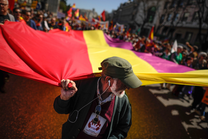 People hold a giant flag of Spain's second Republic during a demonstration by Republicans in Madrid, on April 14, 2013 to commemorate the 82nd anniversary of the Second Republic (AFP Photo / Pedro Armestre) 