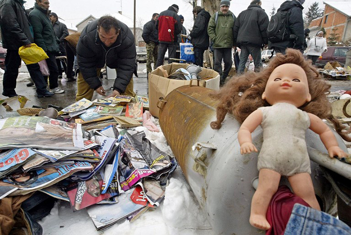 A man searches through magazines displayed for sale among other used things at a market in Belgrade. (AFP Photo / Koca Sulejmanovic)