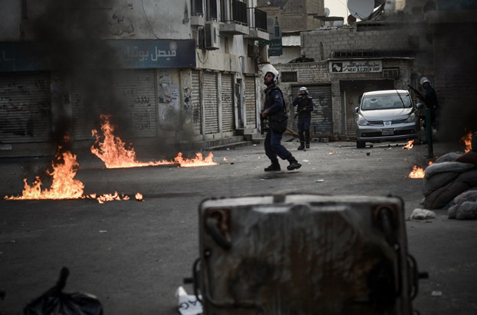 Bahraini riot police run for cover from petrol bombs thrown by anti-regime protestors during clashes following an anti-regime demonstration in solidarity with jailed political activists and against the upcoming Bahrain Formula One Grand Prix which will take in Manama on April 21, in the village of Sanabis, west of Manama, on April 13, 2013. (AFP Photo / Mohammed Al-Shaikh)