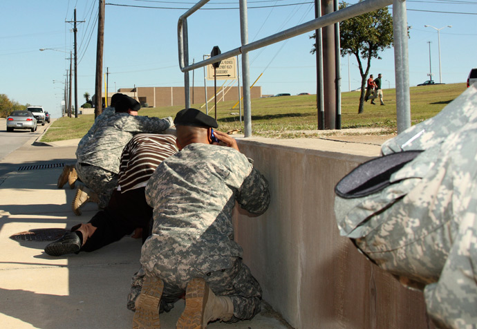 Bystanders crouch for cover as shots rang out from Fort Hood's Soldier Readiness Processing Center, while law enforcement officers run toward the sound of the gun, November 5, 2009 (Reuters / Jeramie Sivley)