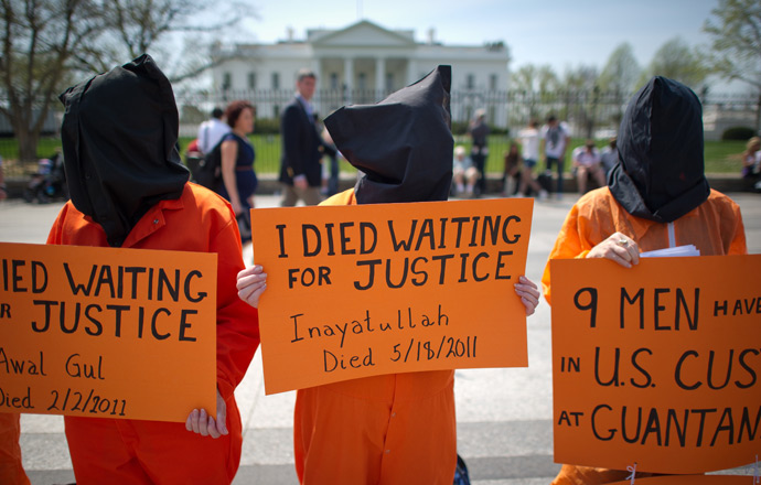 Black hooded human rights activists hold banners demanding the closing of Guantanamo during a protest, part of the Nationwide for Guantanamo Day of Action, outside the White House in Washington DC on April 11, 2013 (AFP Photo / Mladen Antonov)