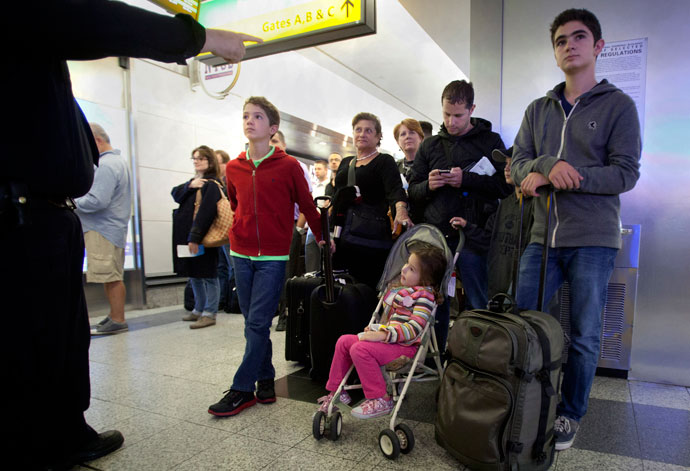 A family listens to a police officer give them instructions in the security line at LaGuardia airport after it was shut down for a time due to a security scare in New York, April 16, 2013.(Reuters / Carlo Allegri)