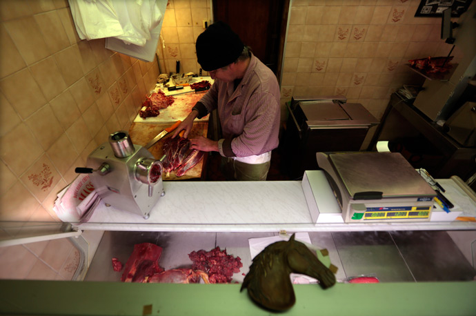 A butcher, prepares horsemeat as he works in his horse butchery shop in the old city of Nice (Reuters / Eric Gaillard)