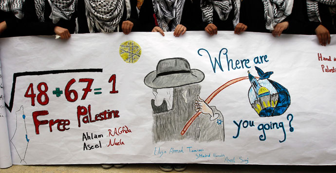 Palestinian school girls hold a banner during a rally marking Prisoner Day in the West Bank city of Hebron April 17, 2013.(Reuters / Ammar Awad)