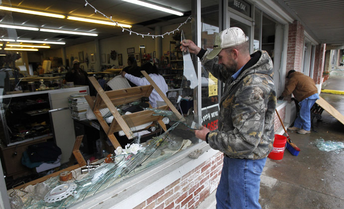 Brandon Smith removes broken glass from the West Thrift Shop after an explosion at a fertilizer plant damaged the store in the town of West, near Waco, Texas April 18, 2013 (Reuters)