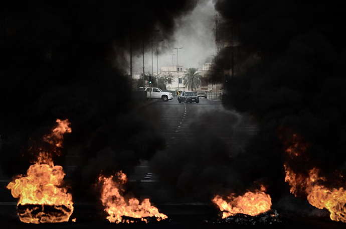 Tyres placed on the road by anti-regime protestors are burning during clashes with riot police following a protest against the arrival of Bahrain Formula One Grand Prix on April 18, 2013 in the village of Diraz, west of Manama. (AFP Photo / Mohammed Al-Shaikh)