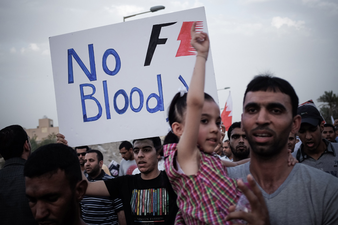 A Bahraini protestor holds up a poster against the country's upcoming Formula One Grand Prix during a demonstration on the sidelines of an anti-regime rally in support of political activists held in jail in the village of Jid Ali, north-east of Isa Town, on April 17, 2013 (AFP Photo / Mohammed Al-Shaikh) 