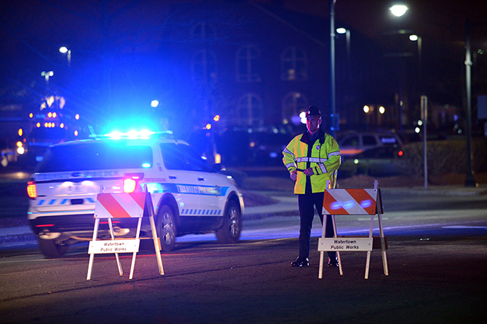 A police officer at a check point as a search for the second of two suspects wanted in the Boston Marathon bombings takes place April 19, 2013 in Watertown, Massachusetts. (AFP Photo / Stan Honda)