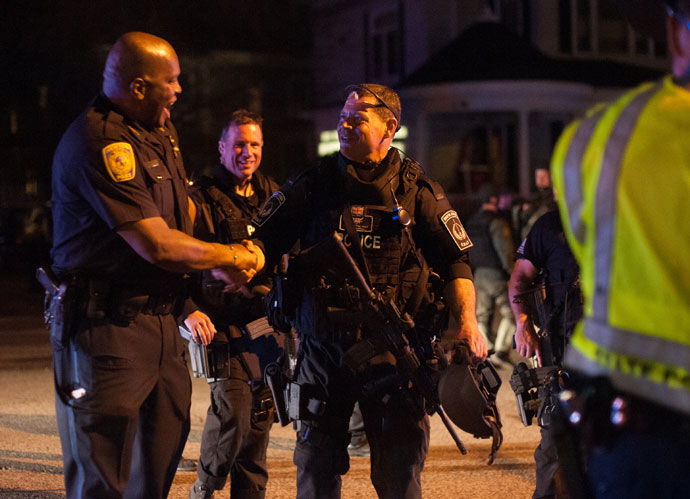 Police officers and SWAT team members greet each other after a police assault on a house on Franklin Street in Watertown, Massachusetts April 19, 2013.(Reuters / John Taggart)