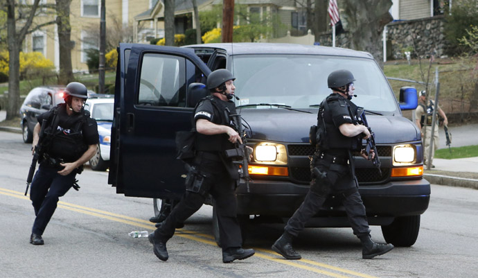 Police SWAT team members run towards the scene of gunfire as police assault a house on Franklin Street during the search for Dzhokhar Tsarnaev, the surviving suspect in the Boston Marathon bombings, in Watertown, Massachusetts April 19, 2013. (Reuters/Jim Bourg)
