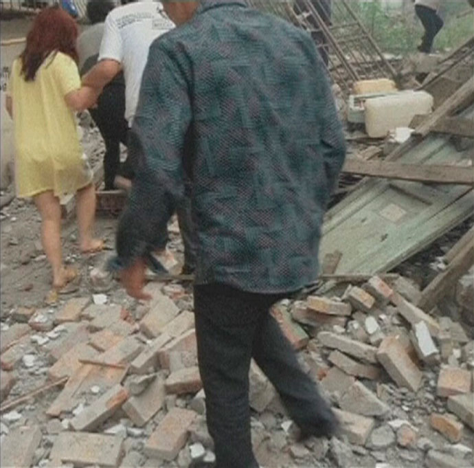 People walk on rubble after a 6.6 magnitude earthquake hit southwestern China's Sichuan province in this April 20, 2013.(Reuters / China Central Television)