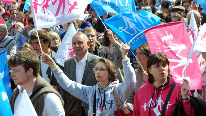 Opponents of a gay marriage wave flags as they walk during a demonstration of the anti-gay marriage movement "La Manif Pour Tous" (Demonstration for all!) on April 21, 2013 in Paris.(AFP Photo / Pierre Andryieu) 