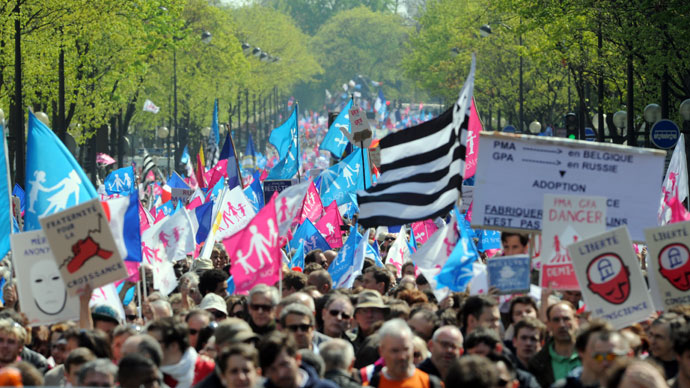 Thousands of opponents of a gay marriage wave flags as they walk during a demonstration of the anti-gay marriage movement "La Manif Pour Tous" (Demonstration for all!) on April 21, 2013 in Paris.(AFP Photo / Pierre Andryieu) 