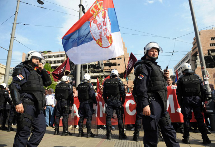 People wave flags in front of police officers during a protest against the accord on the normalisation of relations between Serbia and Kosovo, on April 22, 2013 in Belgrade. (AFP Photo / Alexa Stankovic)