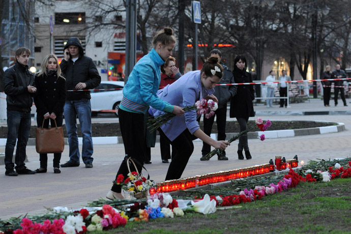 City residents lay flowers to the site of a shooting spree on Narodny Boulevard in Belgorod which claimed six lives. (RIA Novosti/Mikhail Malykhin)