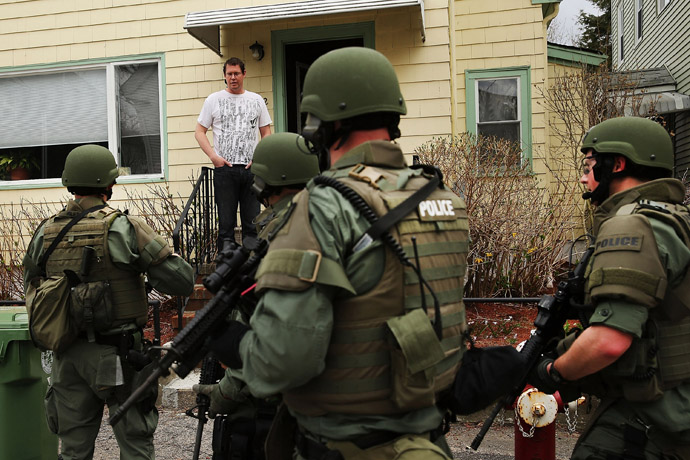 Members of a police SWAT team talk to a man while conducting a door-to-door search for 19-year-old Boston Marathon bombing suspect Dzhokhar A. Tsarnaev on April 19, 2013 in Watertown, Massachusetts. (Spencer Platt/Getty Images/AFP)