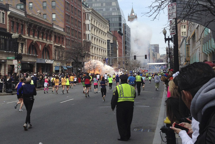 Runners continue to run towards the finish line of the Boston Marathon as an explosion erupts near the finish line of the race in this photo exclusively licensed to Reuters by photographer Dan Lampariello after he took the photo in Boston, Massachusetts, April 15, 2013. (Reutrers/Dan Lampariello)