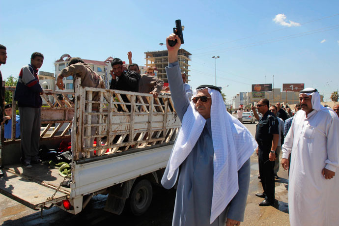 A man fires a gun during a funeral for protesters who died during a clash between Iraqi forces and Sunni Muslim protesters in Kirkuk, 250 km (155 miles) north of Baghdad April 24, 2013.(Reuters / Ako Rasheed)