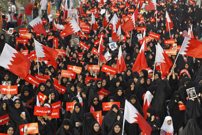 Protesters holding banners that read "I Love Bahrain" participate with Bahraini flags during an anti-government rally organised by main opposition group Al Wefaq in Budaiya, west of Manama April 19, 2013. (Reuters/Hamad I Mohammed)