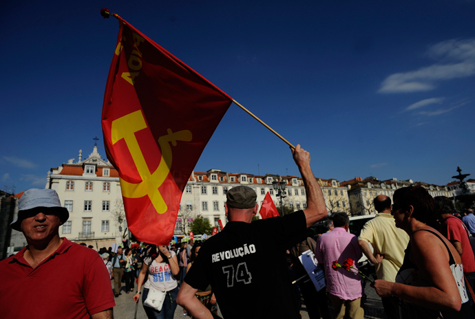 A demonstrator waves a comunist flag and wears a T-shirt reading "revolution 74" in Lisbon's main Rossio Square during the celebration of the1974 Revolution anniversary on April 25, 2013 (AFP Photo / Francisco Leong)