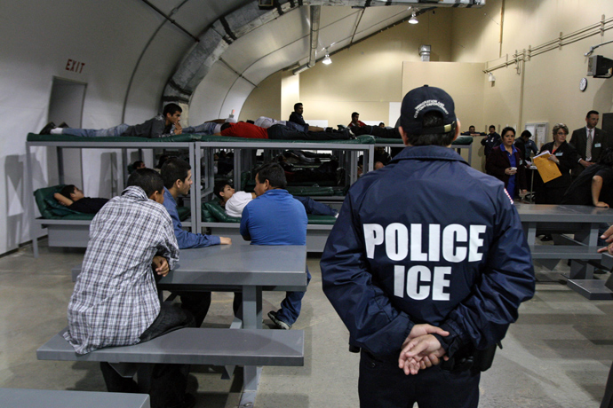 An Immigration and Customs Enforcement (ICE) officer guards a group of 116 Salvadorean immigrants waiting to be deported at the Willacy Detention facility in Raymondville, Texas (AFP Photo / Jose Cabezas)