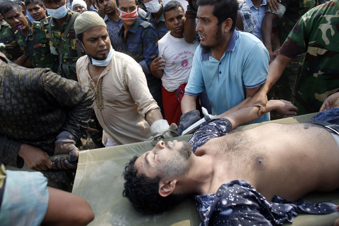 Rescue workers carry a garment worker alive from the rubble of the collapsed Rana Plaza building, in Savar, 30 km (19 miles) outside Dhaka April 26, 2013. (Reuters/Andrew Biraj)