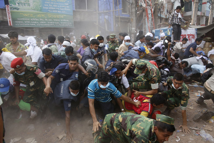 Rescue workers, army personnel, police and members of media run after they heard someone shouting that a building next to Rana Plaza is collapsing during a rescue operation in Savar, 30 km (19 miles) outside Dhaka April 26, 2013. (Reuters/Andrew Biraj)
