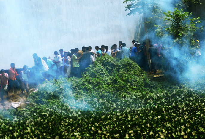 Bangladeshi police fire tear gas after relatives of the missing and dead burst into angry protests at the disaster site of an eight-storey building that collapsed 48 hours earlier in Savar, on the outskirts of Dhaka, on April 26, 2013. (AFP Photo/Munir Uz Zaman)