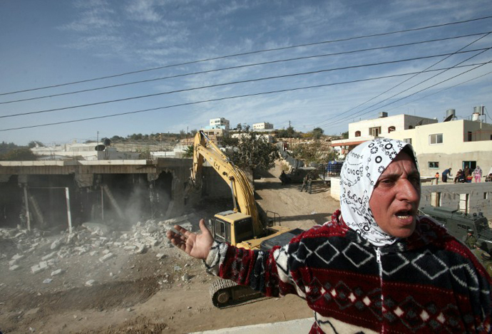 A Palestinian woman from the Jaber family shouts as Israeli bulldozers demolished a series of shops built without a permit in the vicinity of the Israeli settlement of Kiryat Arbaa. (AFP Photo / Hazem Bader)