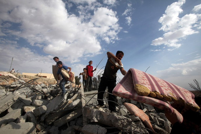 Palestinians search for their belongings in the rubble of their houses, which were demolished by Israeli bulldozers as they were built illegally without a permit in the southern area of Yatta village, south of the West Bank town of Hebron, on November 6, 2012. (AFP Photo / Hazem Bader)