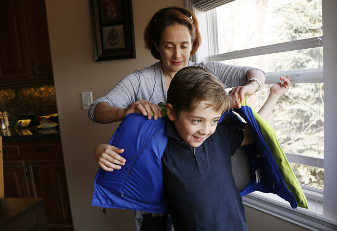 Sheirn Adi helps her son Bilal, 8, put on a bullet proof vest/backpack combination called the V-Bag sold by Elite Sterling Security LLC (ESS) in Aurora, Colorado March 19, 2013. (Reuters / Rick Wilking)