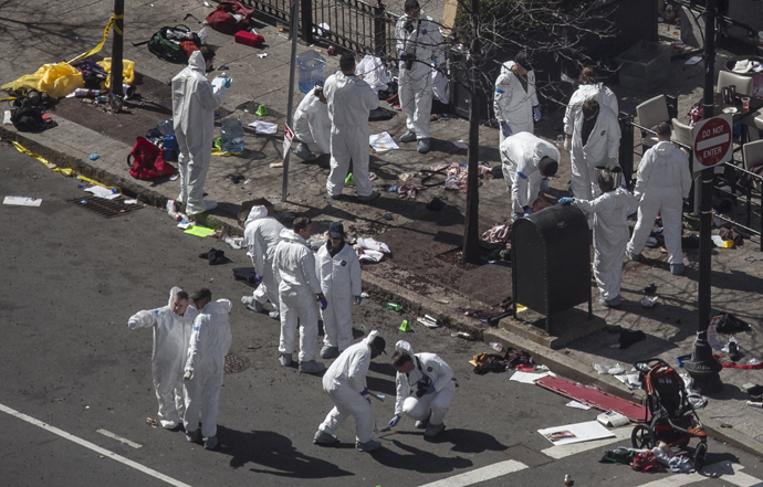 Investigators survey the site of a bomb blast on Boylston Street a day after two explosions hit the Boston Marathon in Boston, Massachusetts April 16, 2013. (Reuters / Adrees Latif)