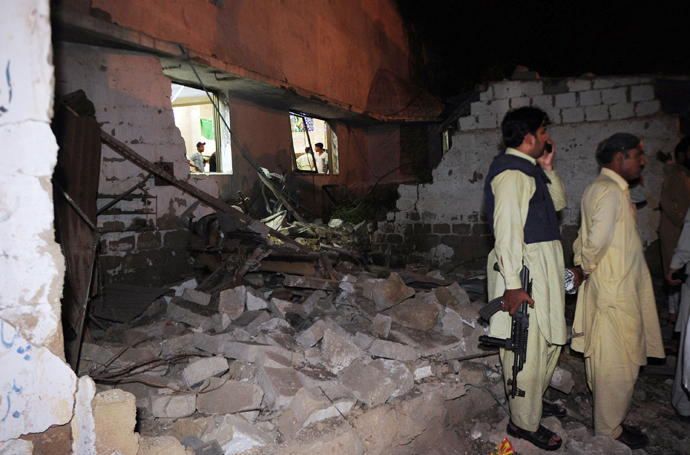 Pakistani security officials stand at the site of a bomb explosion in Karachi on April 27, 2013 (AFP Photo / Asif Hassan)