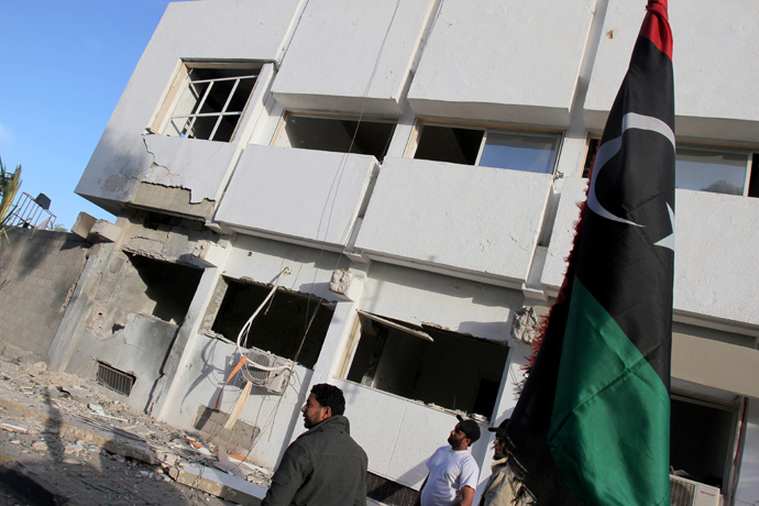 Libyan security forces and bystanders walk outside a damaged police station on April 27, 2013 in Benghazi (AFP Photo / Abdullah Doma)